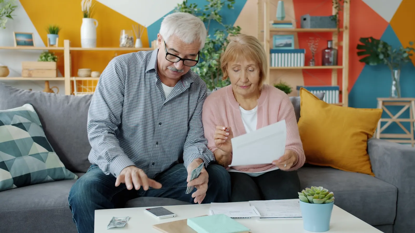 Un couple senior consulte ensemble des documents à la maison